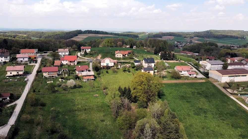 Luftaufnahme des Grundstücks von Süden aus gesehen. Das Haus oben im Bild, Bäume unten.