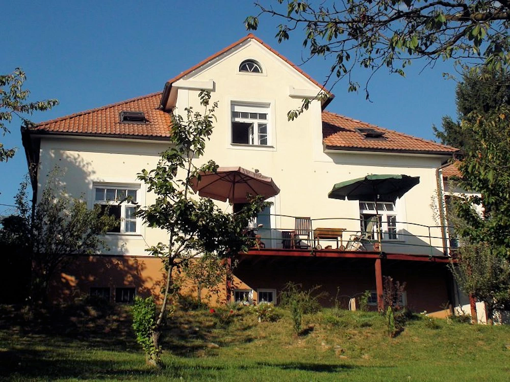 Blick auf das Haus und den großen Balkon vom Südgarten aus